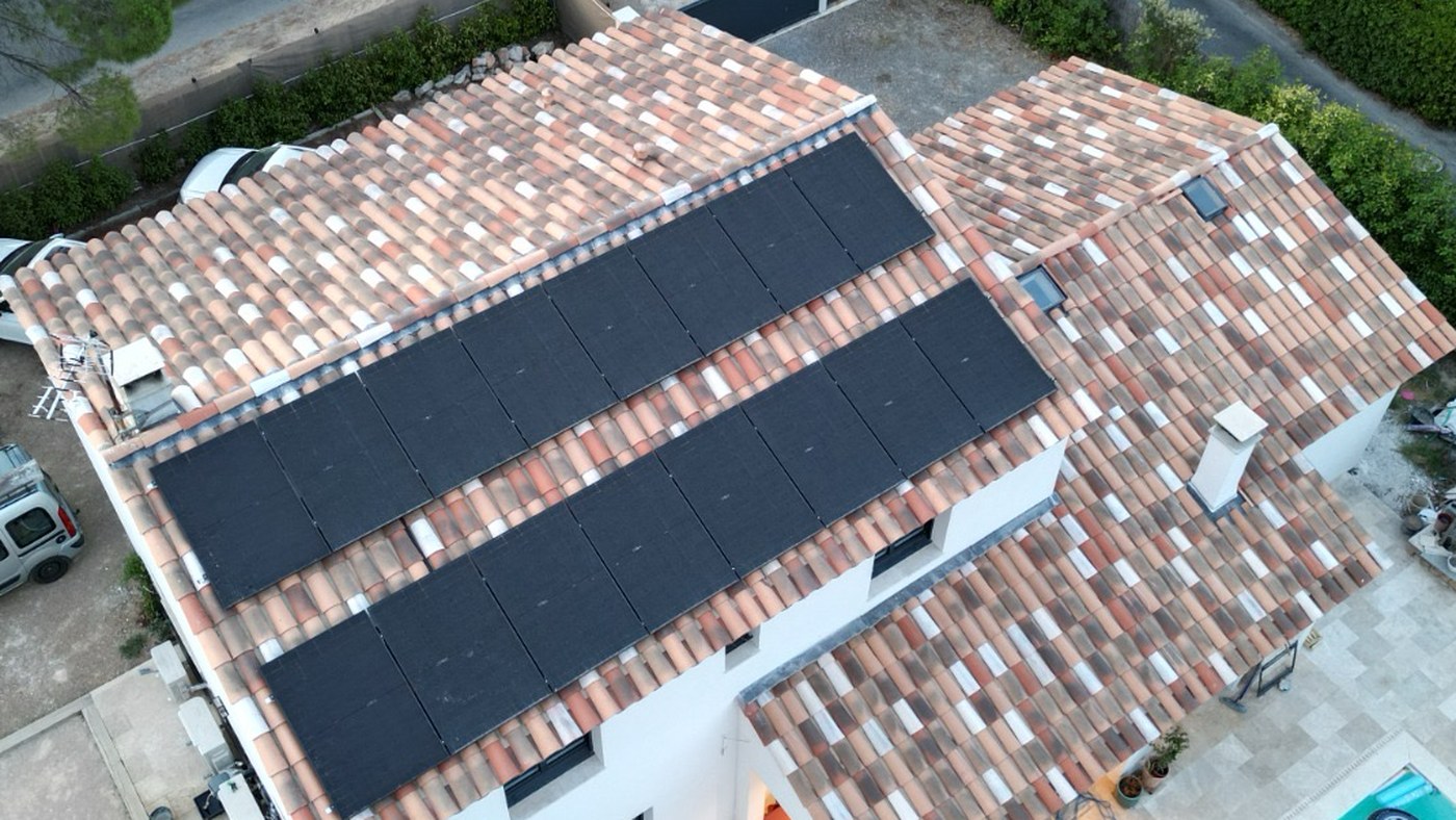 Vue aérienne d'une installation photovoltaïque sur une toiture en tuiles à Lorgues : deux rangées de panneaux alignées sur le pan principal
