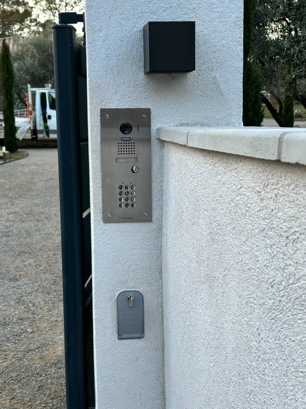 Pilier terminé, vue d'ensemble : platine de visiophone et serrure à clé du portail.