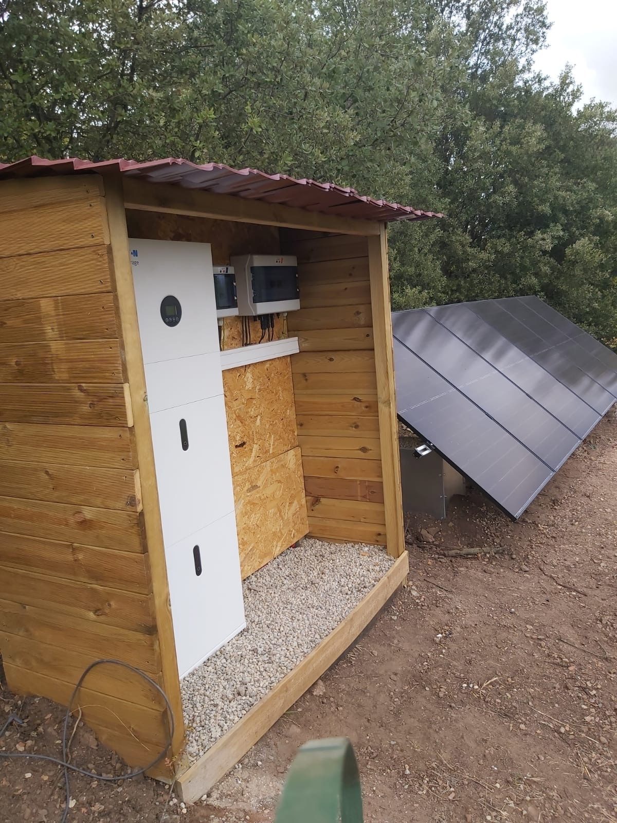 Intérieur de l'abri technique : onduleur, batterie et coffret électrique