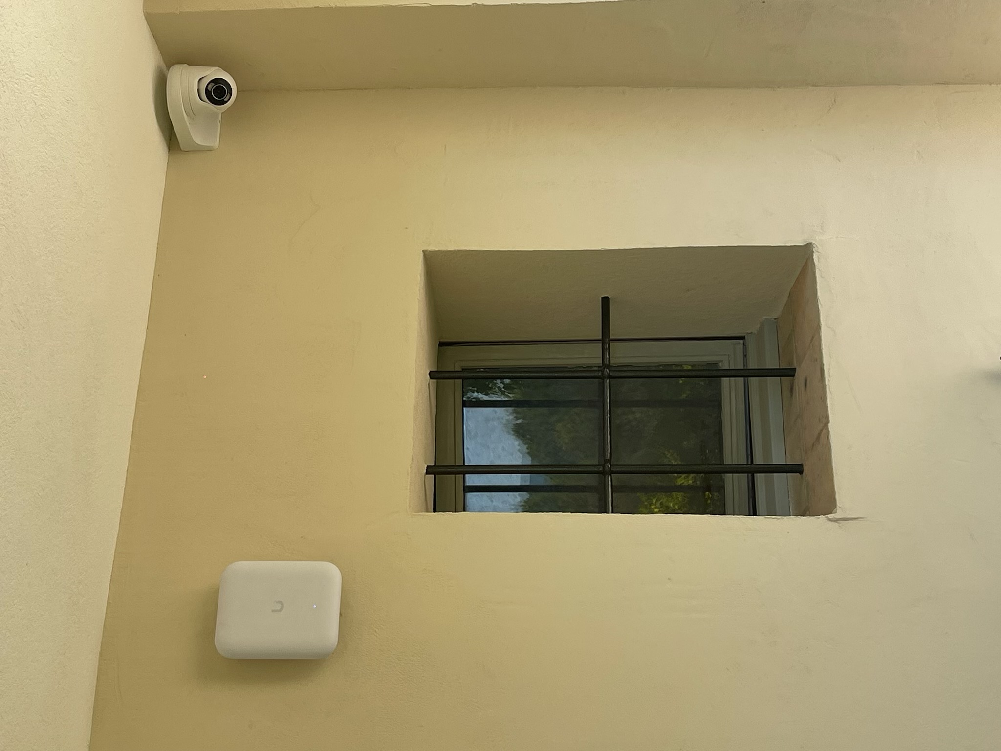 Caméra de vidéosurveillance et point d'accès wifi extérieur posés en angle de façade